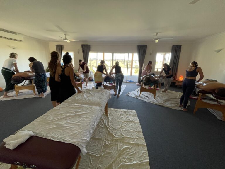 a group of people in a room learning Lomi Lomi Massage at Hum Healing